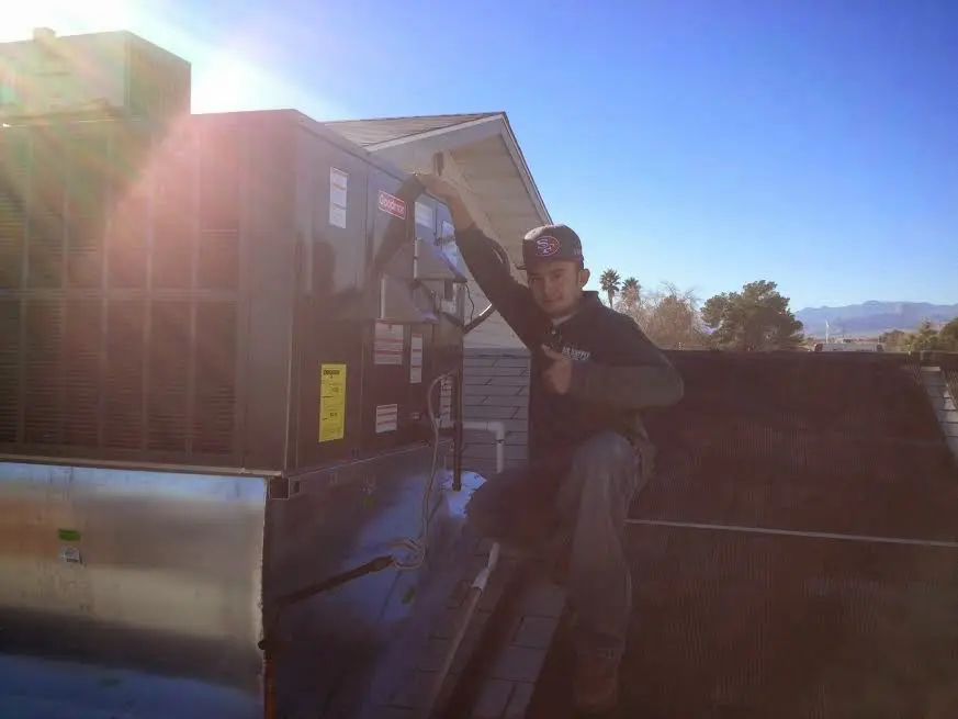 HVAC technician performing Air Duct Cleaning on a rooftop unit in Maryville
